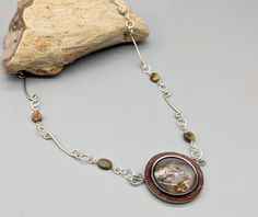 This necklace features an circular agate stone that has been set in a polymer clay and metal bezel. The pendant is attached a decorative sterling silver and stone beaded chain. MATERIALS & DIMENSIONS: - Stone is Agate - Chain length is 17 inches - Pendant size is 1 1/4 inches high and 1 1/4 inch wide Agate Stone, Beaded Chain, Chain Lengths, Stone Beads, Chain Length, Pendant Necklaces, 4 Inch, Seattle, Agate