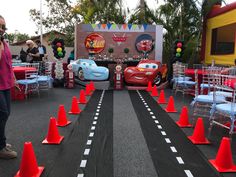 cars birthday party setup with race track and cones on the road for kids to play in