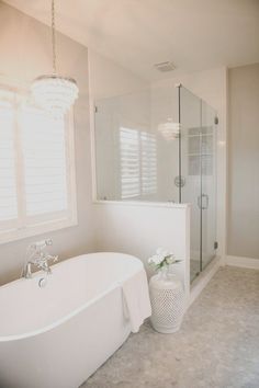 a white bath tub sitting next to a walk in shower