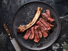 sliced steak on a plate with knife and fork