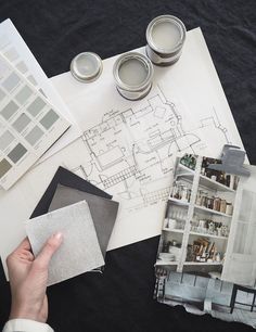 a person is working on architectural drawings and painting them with watercolors in their hands