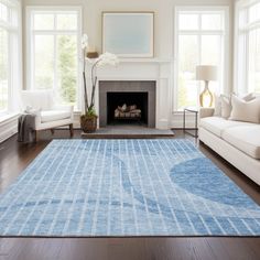 a living room filled with furniture and a blue rug on top of a hard wood floor