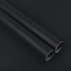 a close up view of a black surface with two metal tubes sticking out of it