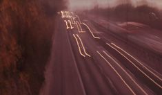 blurry photograph of cars driving down a highway in the foggy night time hours