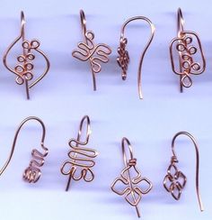 several pairs of earrings are shown on a white surface