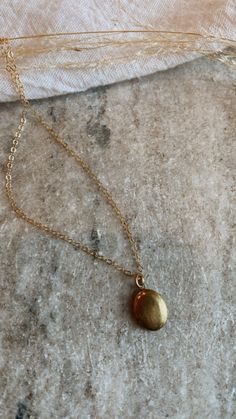 Mini brass locket on a gold fill chain. The daintiest oval shape, minimal + lovely. Can be stamped with one initial or birth flower on the inside, or filled with a picture. Dainty Brass Charm Necklace With Round Pendant, Oval Locket Necklace For Everyday, Everyday Oval Locket Necklaces, Yellow Gold Brass Charm Necklaces With Oval Pendant, Dainty Gold Brass Charm Necklace, Minimalist Jewelry With Oval Locket Pendant, Gold Locket Necklace With Delicate Chain And Round Pendant, Gold Locket Necklace With Delicate Round Pendant, Gold Oval Charm Necklace With Adjustable Chain