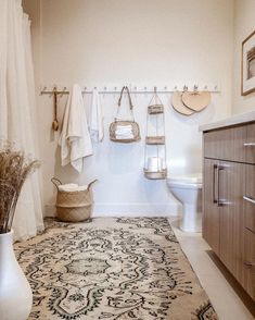 a bathroom with a rug, towel rack and other items on the wall above it