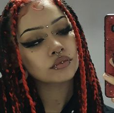 a woman with red dreadlocks and piercing on her nose