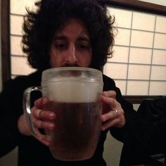 a man is holding a large mug in front of his face