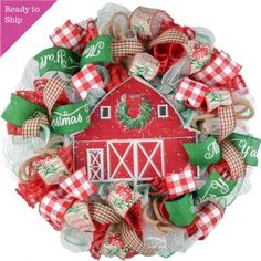 a christmas wreath with red and green decorations on the front, white barn in the background