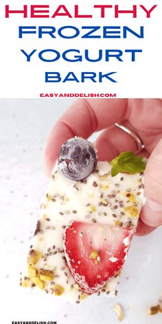 a person holding a piece of food with fruit on it and text overlay that reads healthy frozen yogurt bark