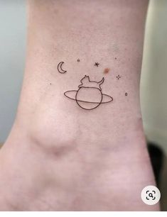 a small tattoo on the ankle that has an image of saturn and stars above it