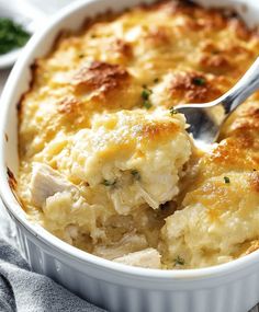 a close up of a casserole dish with chicken and cheese in it on a table