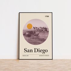 a poster with the name san diego on it in front of a white wall and wooden floor