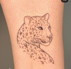 a tattoo on the leg of a woman with a cheetah head in black ink