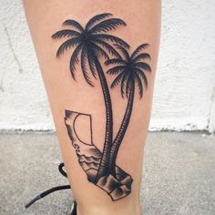 a woman's leg with a palm tree tattoo on it