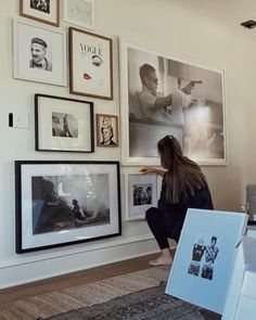 a woman sitting on the floor in front of pictures