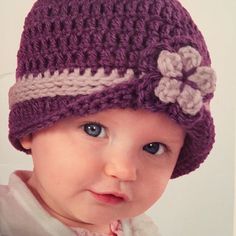 a baby wearing a purple crocheted hat