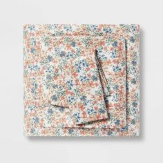 an image of a floral print pocket square on a white background with pink, blue and orange flowers