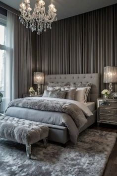 a bedroom with a large bed, chandelier and two lamps on the wall