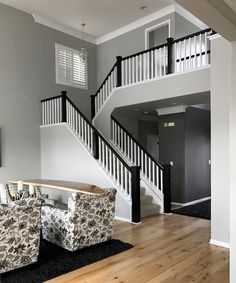 an empty living room with stairs leading up to the second floor and a couch in front of it