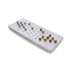 a white marble board with gold and silver balls on it's sides, against a white background