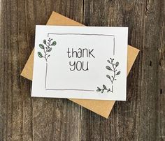 a thank you card sitting on top of a wooden table