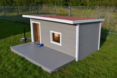 the dog house is built into the grass with its door open to let in some light