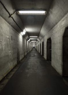 an empty tunnel with light at the end and no people in it on either side