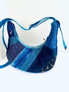 a handbag made out of old jeans on a white surface with a blue strap