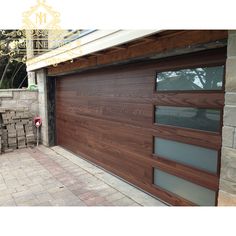 a wooden garage door in front of a brick wall