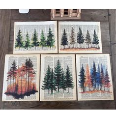 four books with trees painted on them sitting on a wooden table next to a basket