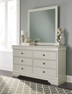 a white dresser and mirror in a room