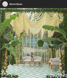 an outdoor wedding setup with chairs and greenery on the side, decorated in gold