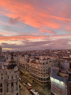 an aerial view of the city with buildings and cars in it at sunset or dawn