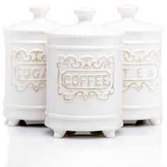 three white canisters with ornate designs on each one and the word coffee printed on them