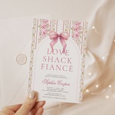 a person holding up a card that says love shack flanne with a pink bow on it