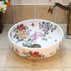 a sink with flowers painted on it and a faucet