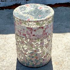 a mosaic tiled trash can sitting on the sidewalk