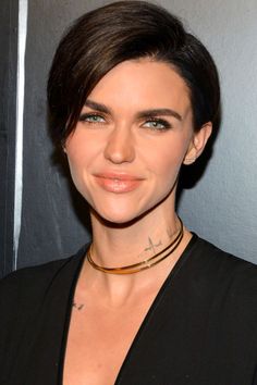 a close up of a person wearing a black shirt and choker on her neck