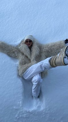 a person laying in the snow with their arms out