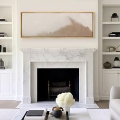 a living room filled with furniture and a fire place in front of a white fireplace