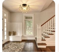 an empty room with stairs and a chandelier