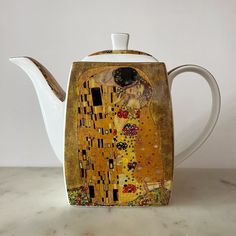 a ceramic teapot with an image of the kiss on it