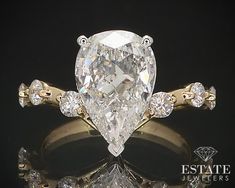 a pear shaped diamond engagement ring with gold accents