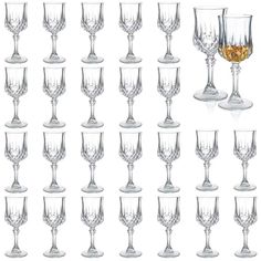 many wine glasses are lined up together on a white background, with one empty glass in the middle