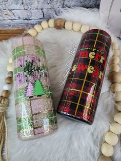 two bottles are sitting next to each other on a white fur covered floor with beads