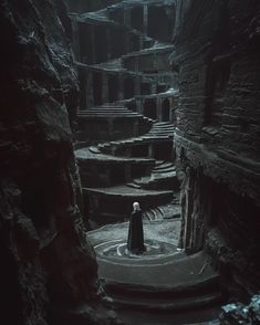 a person standing in the middle of a dark cave filled with stairs and stone steps