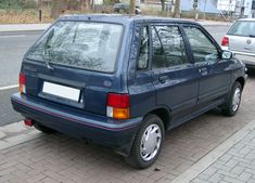 a blue car is parked on the side of the road