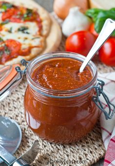 a jar of tomato sauce next to a pizza